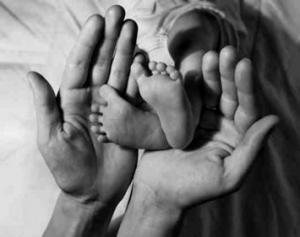 Dziecięce stópki w dłoniach rodzica